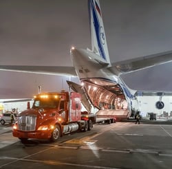 Step-deck semi backed up to an Antonov aircraft