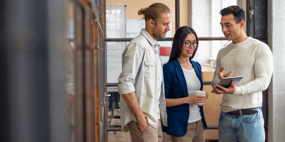 Group dressed in business casual attire meeting in the hallway