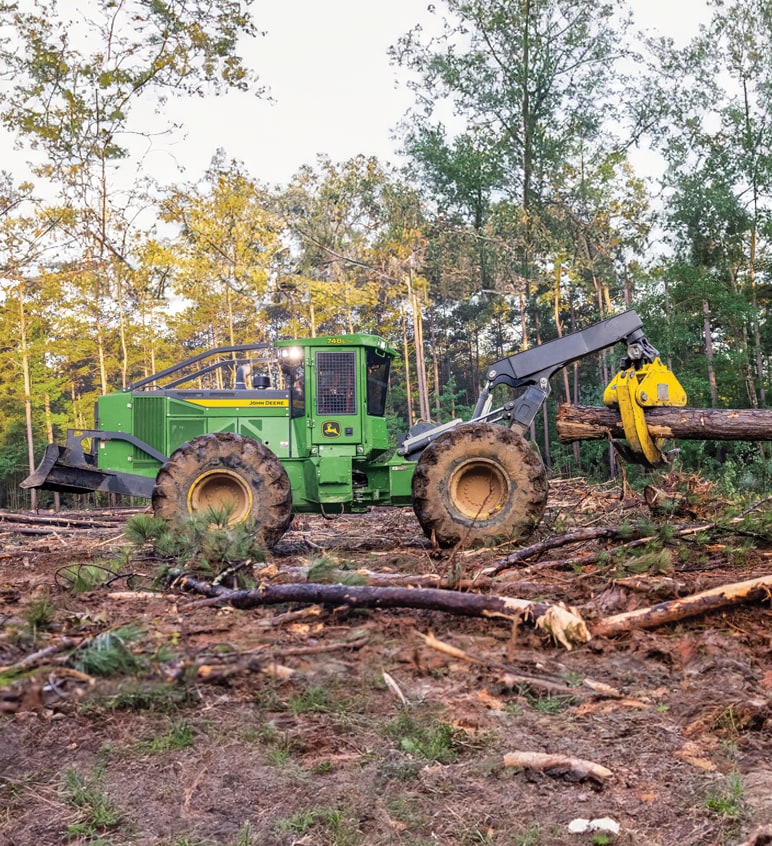 L-III Skidder in the woods holding up a tree log.