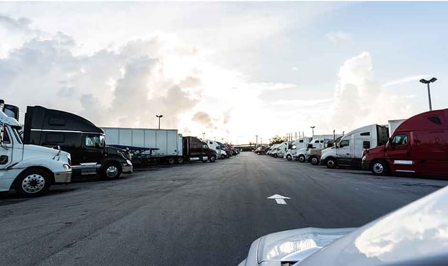 Many trucks parked at a truck stop