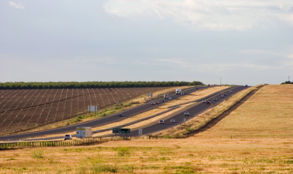 Trucks and passenger vehicles travel through farmland