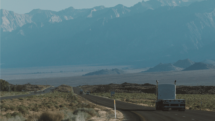 flatbed-truck-driving-into-mountains