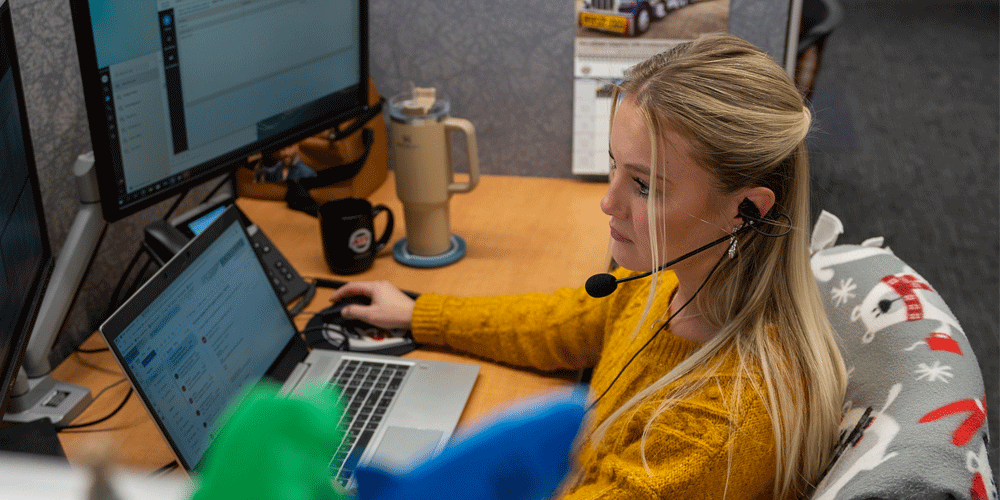 Sales rep on a headset at her desk.