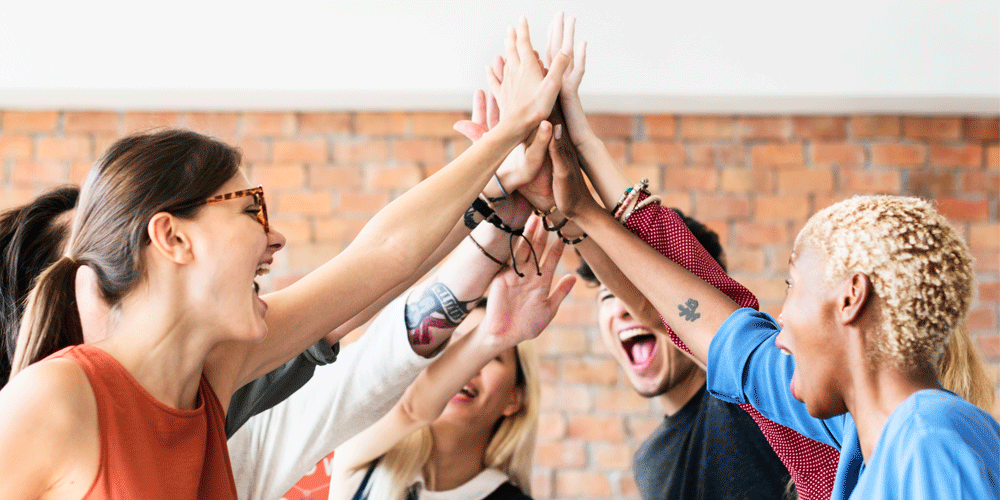A group of coworkers giving high fives happily.